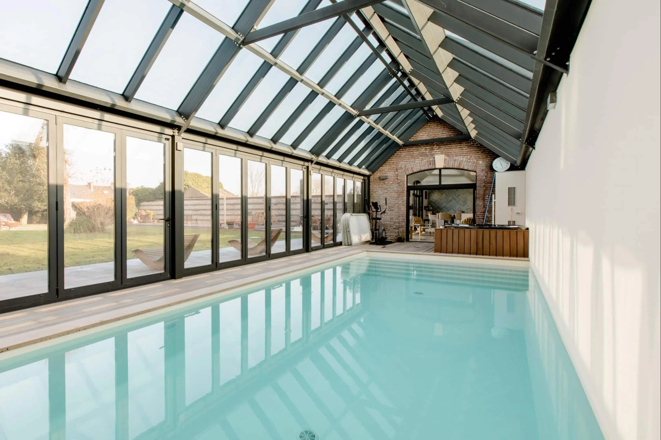 Piscine intérieure chauffée sous une verrière d'acier